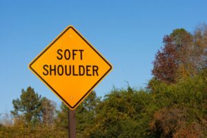 road sign warning of a soft shoulder