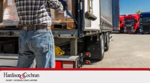 Worker Loads Boxes Onto a Truck at a Shipping Yard