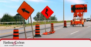 Construction zone with traffic cones and warning signs along a Raleigh, NC highway.