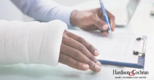 Injured Greensboro worker reviewing a workers' compensation claim form to avoid common filing mistakes.